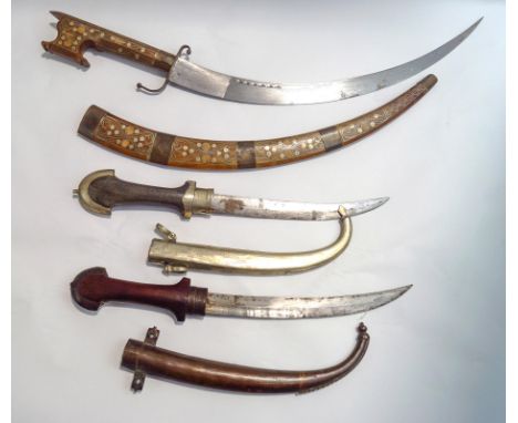A Moroccan dagger, with curved blade and ornate inlaid white metal decoration to wooden sheath and handle, 62cm long overall,