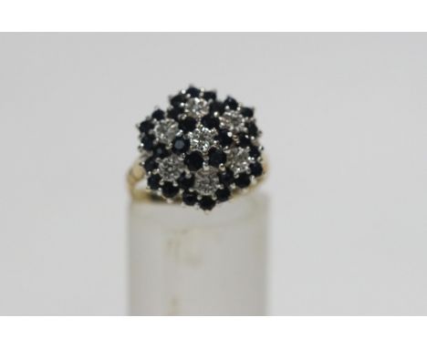 A sapphire and diamond 9 carat gold cluster ring, the single cut diamonds illusion set, finger size M1/2, 4 g gross