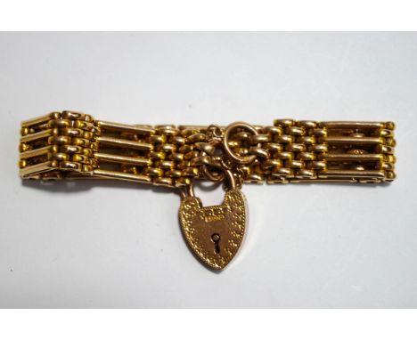 An Edwardian four bar gate bracelet, stamped '9ct', with textured links to a padlock clasp, 24 g gross