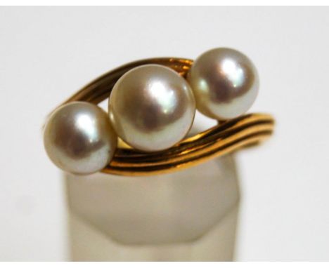 A Mikimoto three stone cultured pearl ring, stamped makers mark and 'K14', the graduated pearls of approximately 7.7 mm and 6