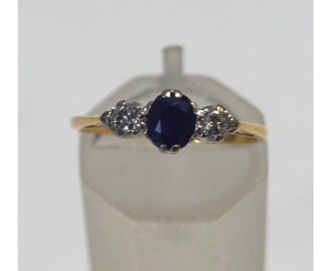 An 18ct gold, sapphire and diamond three stone ring, centred with an oval mixed-cut sapphire between round brilliant diamonds