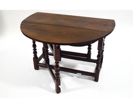 A late 17th Century oak oval gate leg table on turned legs linked by stretchers, 67.5cm high x 122cm wide (fully open) x 106c