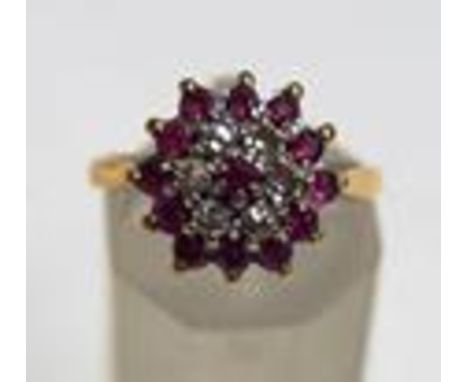 A diamond and ruby cluster ring, stamped '18ct', the central ruby enclosed by six single cut diamonds and further rubies to t