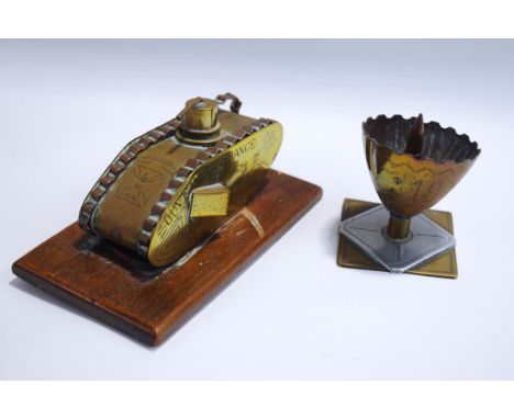 Two items of First World War trench art: a tank inscribed Arras-Ypres 1919, and a shell case end containing a bullet, inscrib