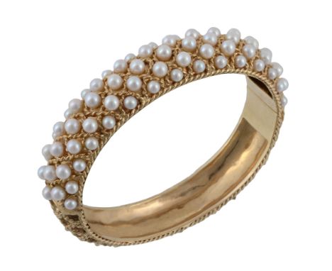  A cultured pearl set bangle, the bangle with applied lattice work rope twist decoration, the front set with cultured pearls,