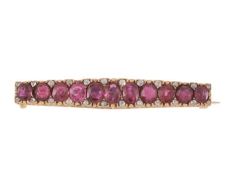  A late 19th century French ruby and diamond bar brooch, circa 1890, the tapered panel set with eleven graduated oval shaped 