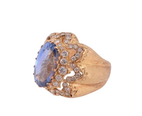 A 1960s sapphire and diamond ring by Mario Buccellati, the oval mixed cut sapphire, weighing 12.06 carats, claw set within a 