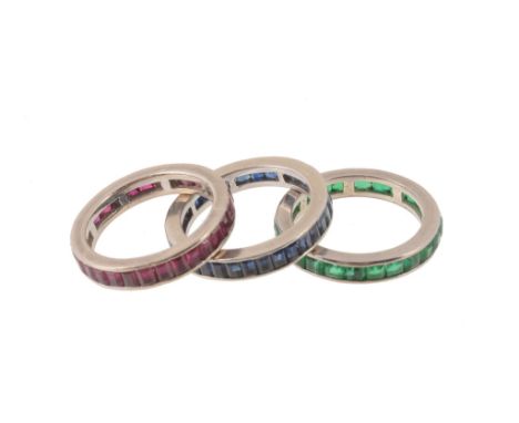  Three gem set eternity rings, each set with either baguette cut rubies, sapphires or emeralds, finger size M-M1/2 