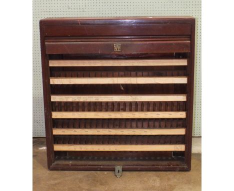 A mid-20th century stained wood ticket cabinet with tambour front enclosing multiple ticket compartments within, 85cm wide, 9