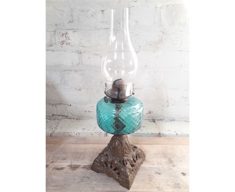 A late Victorian turquoise glass oil lamp with cast metal base and glass flue, height 48cm. 