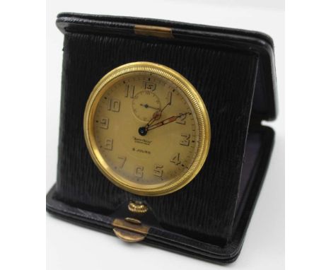 A 'MAPPIN &amp; WEBB' TRAVEL CLOCK, housed in a black leather folding case, the circular dial with Arabic numerals and subsid