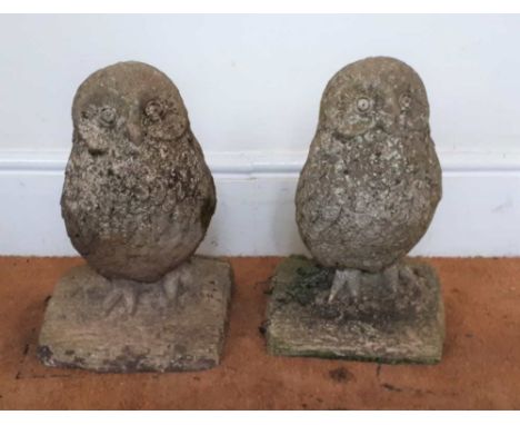 A PAIR OF CAST CONCRETE OWLS on simulated tree trunk bases, each 46cm high 