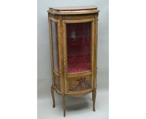A REPRODUCTION FRENCH DESIGN VITRINE profusely decorated with gilt metal mounts, single glazed cupboard door, opening to reve