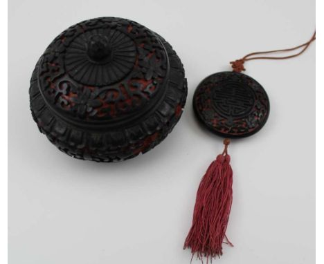 A CHINESE CARVED LACQUER BOWL, with cover, red &amp; black floral decoration over a brass base, blue enamel lined, 10cm in di