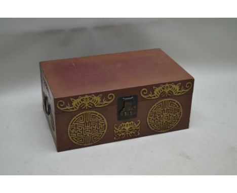A 20TH CENTURY CHINESE TRUNK, tan colour with gilded mons decoration, and iron side carry handles, 66cm x 41cm x 28cm 