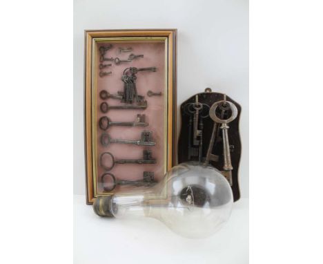 A KEY COLLECTION, the largest, 17cm down to some kidney bow cabinet keys, to include one display case and an oak wall rack, t