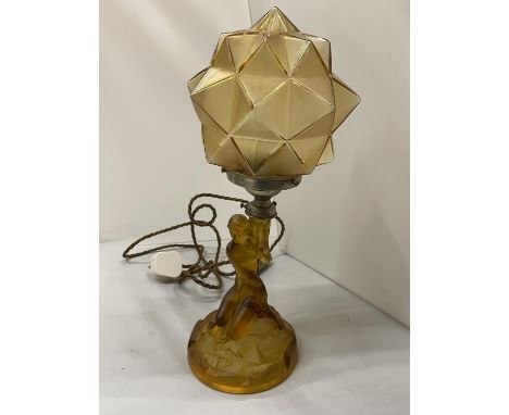 AN ART DECO STYLE AMBER COLOURED GLASS LAMP WITH THE BASE IN THE FORM OF A LADY AND A GEOMETRIC SHADE 