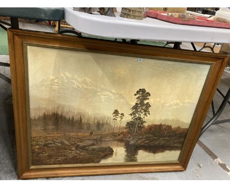 A FRAMED PRINT DEPICTING A LAKE SCENE WITH A STAG AND MOUNTAINOUS BACK DROP 