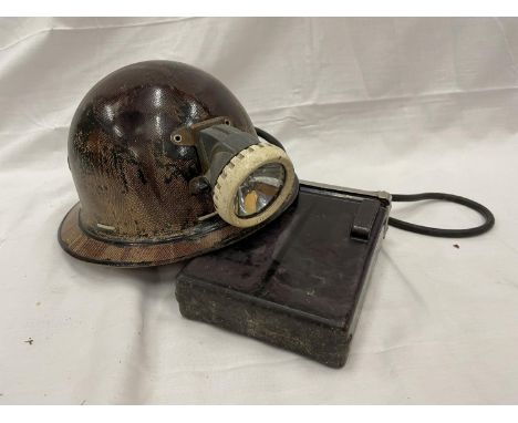 AN OLDHAM AND SONS MINERS LIGHT WITH BATTERY ON A HELMET 