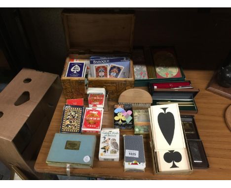 A CARVED WOODEN BOX CONTAINING A QUANTITY OF PLAYING CARDS INCLUDING BAROQUE, PLUS PENS, A LIGHTER AND BRIDGE SCORING CARDS 