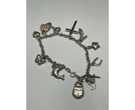 A SILVER CHARM BRACELET WITH ELEVEN CHARMS TO INCLUDE KEYS, HEARTS, DOLPHIN, CROSS, HANDBAG ETC 