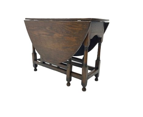 19th century country oak drop leaf dining table, oval top over turned gate-leg supports united by stretchersDimensions: Heigh