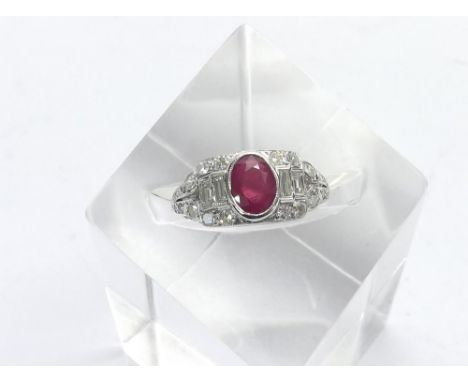 18ct white gold ruby and diamond dress ring in the Art Deco style, the oval ruby estimated 0.9ct approx, in a surround of rou