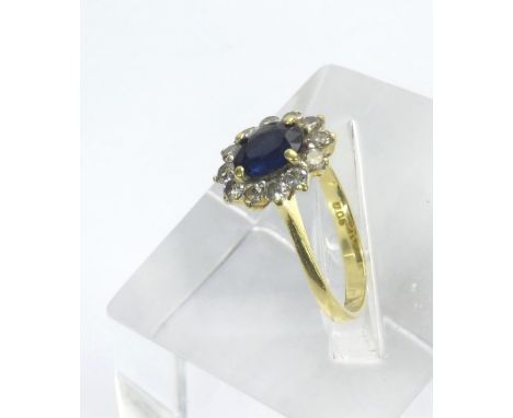 18ct sapphire and diamond oval cluster ring, the central sapphire in a surround of round brilliant cut diamonds in yellow gol