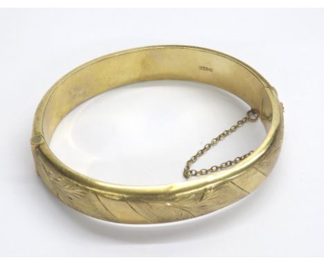 9ct yellow gold engraved hinged bangle, with safety chain, 17.1gm (some bruising)