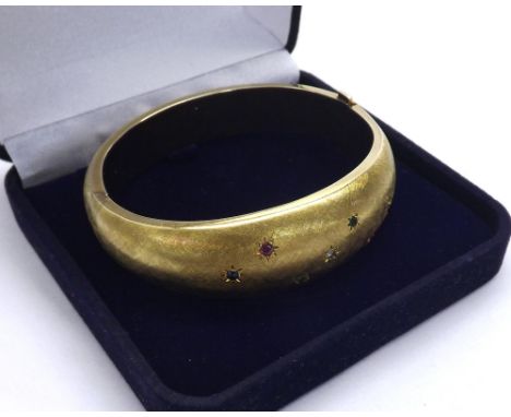14ct yellow gold textured hinged bangle set with a diamond, emeralds, sapphires and rubies, 56.1gm, 70mm wide, box