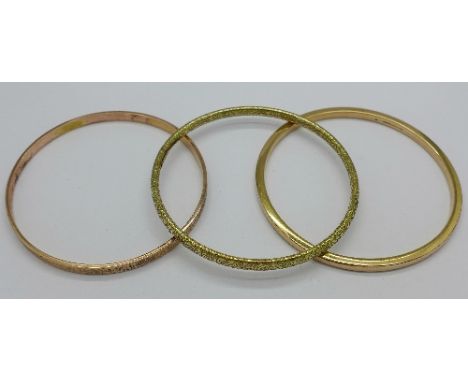 A 9ct gold bangle, 19.1g and two rolled gold bangles