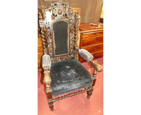 A late 19th century heavily carved parlour armchair, having studded upholstered pad back, seat and arm rests, with barleytwis