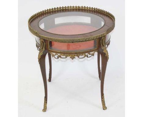 A late 19th century French walnut bijouterie table, the circular tilt-top with central glazed panel within a raised gilt meta