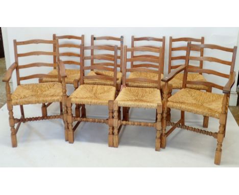 Eight ladder back rush seated oak country dining chairs with bobbin turned front rail (two carvers, six chairs) one chair dam