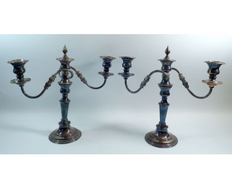 A pair of silver plate on copper three branch candelabra with removable central finials, 33cm tall