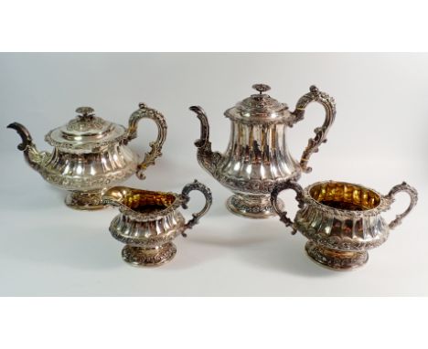 A Georgian silver four piece tea service with rose finials and fluted body, with further floral banding and decoration, Londo