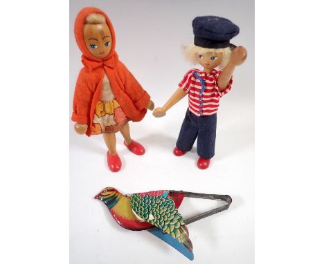 Two vintage peg dolls and a tin plate 'flapping' bird toy 