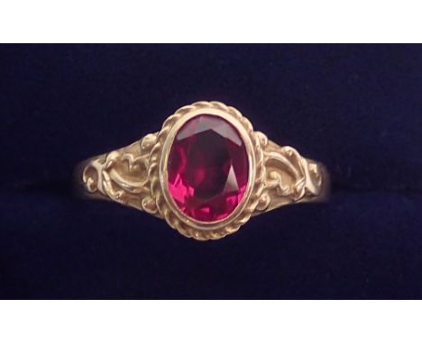 A 14 carat gold ring set red stone on scrollwork shoulders, size R, 3.4g