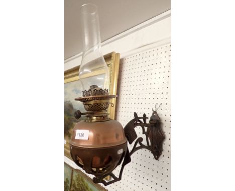 A 19th century copper wall oil lamp with cast iron bracket 