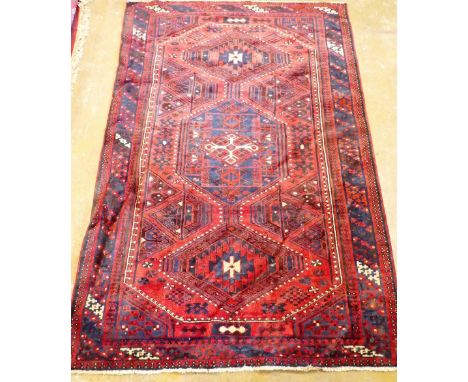 A Turkish carpet with blue triple geometric design on a red ground 249 x 170cm 