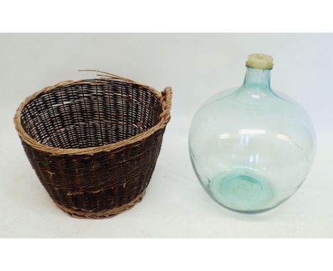 A large vintage green glass carboy, 57cm tall plus wicker basket