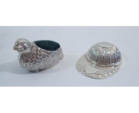 A jockey cap silver caddy spoon, Sheffield 1991 and a chick pin cushion, 5cm