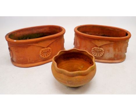 A pair of oval terracotta garden planters and circular planter, 56 x 37cm