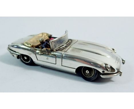 A silver model E Type Jaguar convertible by Gordon Yates with two enamel figures, set ruby rear lights, 10.5cm long
