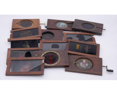 Thirteen mechanical 19th century wooden coloured glass magic lantern slides. Various designs and subjects. 