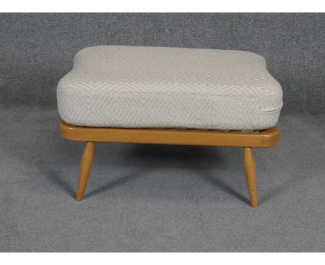 A vintage light beech Ercol style footstool with fitted cushion. L72 W52 H38cm (Damage to webbing as photographed). 