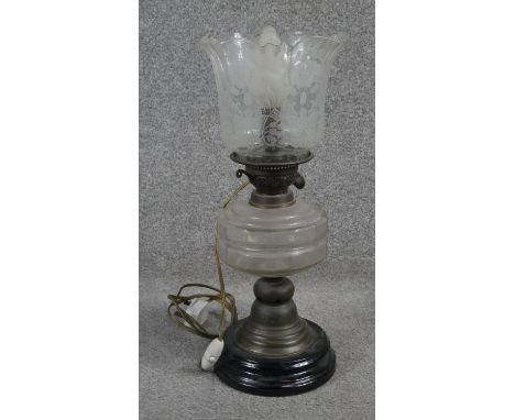 A Victorian brass converted oil lamp with opaque black glass base and frosted and etched glass shade with fluted rim. H.48cm 