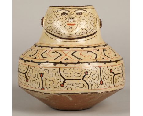 Shipibo terracotta pottery vessel, 20th C, geometric patterns in brown and red surround a face with protruding features. 19cm
