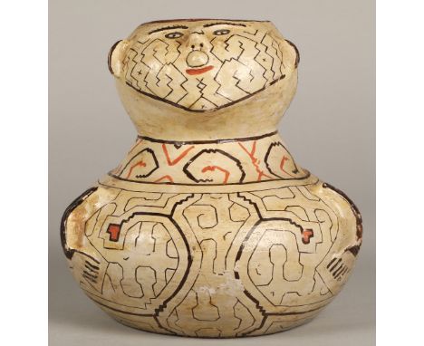 Shipibo terracotta pottery vessel, 20th C, geometric patterns in brown and red surround a face with protruding features and a