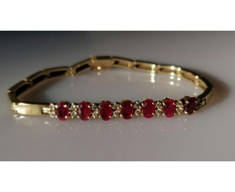 A yellow gold and ruby bracelet with diamond decoration, each ruby approximately 6mm x 4mm, 18 cm, stamped 585, 17.4g